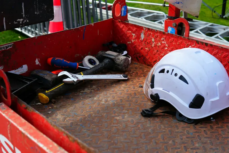 Casque de chantier et outils posés dans la benne d'un véhicule utilitaire